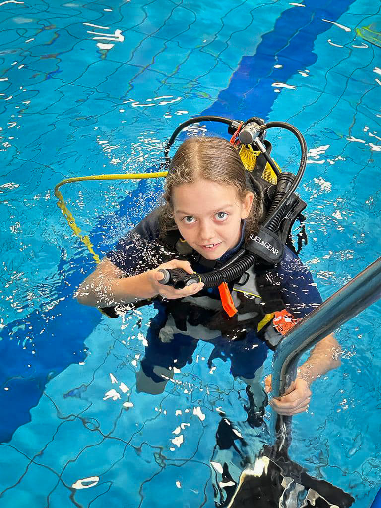 Dziewczynka podczas nurkowania w basenie.